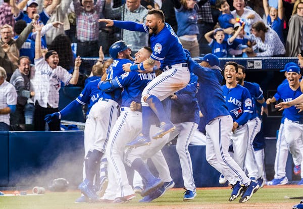 Toronto Blue Jays players celebrate their walk-off win to eliminate the Texas Rangers during the tenth inning to win the American League Division Seri