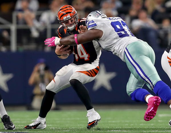 Dallas Cowboys defensive tackle Terrell McClain (97) gets a sack on Bengals quarterback Andy Dalton (14) during the third quarter on Sunday Oct. 9, 20