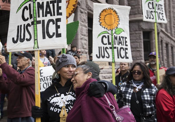 Williamette Hardy, right, of the Red Lake Reservation gets a hug from Gio Cerise of White Earth during a rally Tuesday in Minneapolis. They met at the