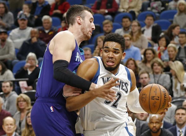 Minnesota Timberwolves' Karl-Anthony Towns, right, drives around Charlotte Hornets' Frank Kaminsky III in the first quarter of an NBA basketball game 