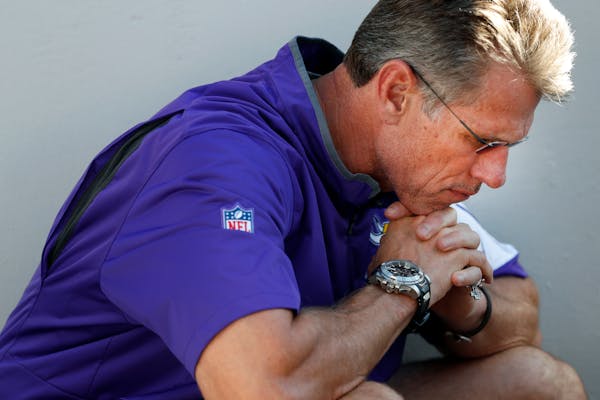 Minnesota Vikings general manager Rick Spielman listens to head coach Mike Zimmer speak during a news conference about the injury to quarterback Teddy