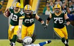 Green Bay Packers' Aaron Rodgers is stopped by Indianapolis Colts' Erik Walden on a third down run during the first half of an NFL football game Sunda