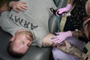 Steve Major, an Iraq war veteran, got his Purple Heart tattooed on his right biceps at no charge by Misty Chastain.
