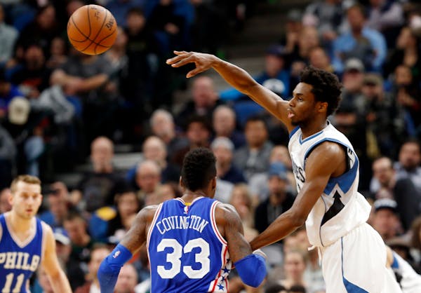 Minnesota Timberwolves' Andrew Wiggins, right, sends a pass over Philadelphia 76ers' Robert Covington in the second half of an NBA basketball game Thu