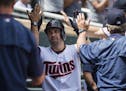 Minnesota Twins second baseman Brian Dozier (2) celebrated with teammates in the dugout after hitting a solo home run to bring the score 5-3 in the fi