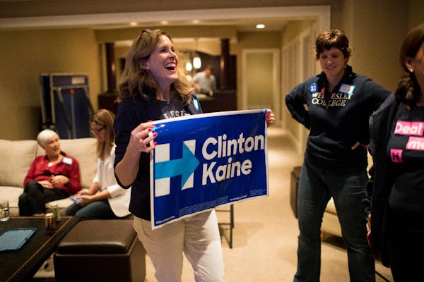 Sara Pearce holds a sign from a guest during an election party for Wellesley College alumni supporting Democratic presidential candidate Hillary Clint