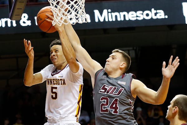 Minnesota's Amir Coffey, left, lays up a shot as Southern Illinois' Rudy Stradnieks defends during the second half of an NCAA college basketball game 