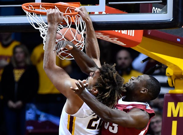 Gophers center Reggie Lynch dunked despite the defensive effort by Arkansas forward Moses Kingsley in the first half Tuesday at Williams Arena.