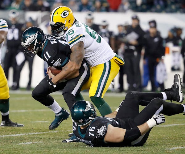 Philadelphia Eagles quarterback Carson Wentz, left, is sacked by Green Bay Packers' Julius Peppers, right, during the fourth quarter on Monday, Nov. 2