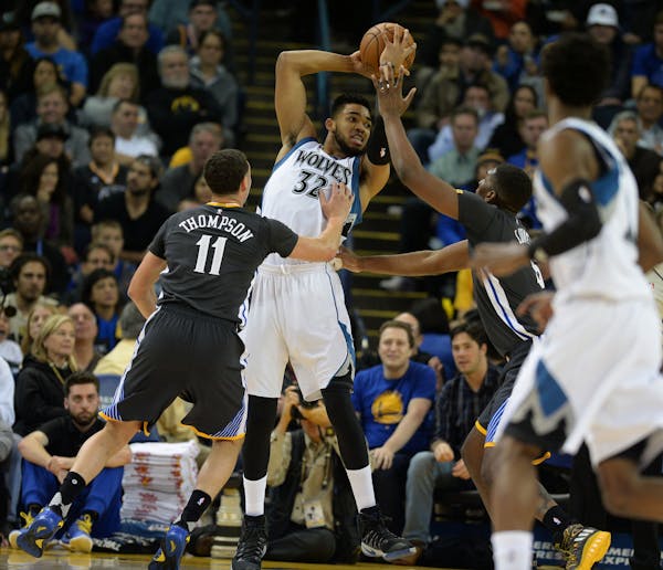 Golden State’s Klay Thompson (11) and Kevon Looney pressured Karl-Anthony Towns on Saturday night in Oakland, Calif. The Warriors beat the Wolves 11