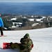 Snowboarders take a rest, and a big view of Lake Superior, at Lutsen Mountains.