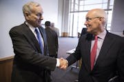 Minnesota Management and Budget commissioner Myron Frans, right, shakes hands with Governor Mark Dayton after the Minnesota Budget and Economic Foreca
