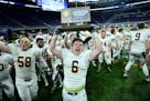 Totino-Grace fullback Brady Bertram (6) celebrated with his team's Class 6A championship trophy Friday night after defeating Eden Prairie 28-20 at the