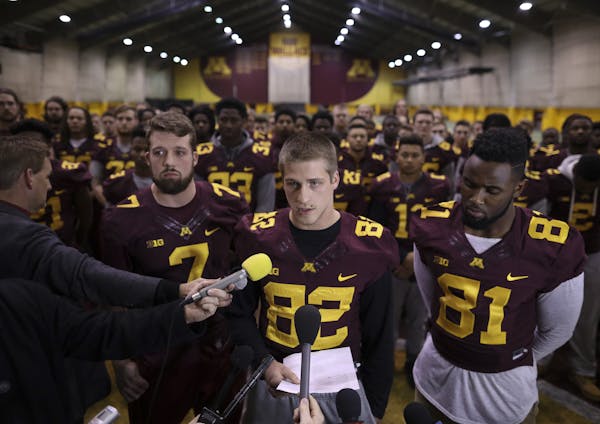 Gophers wide receiver Drew Wolitarsky, center, flanked by quarterback Mitch Leidner, left, and tight end Duke Anyanwu, read the statement on behalf of