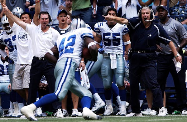 Cowboys head coach Bill Parcells, right, and defensive coordinator Mike Zimmer point the direction Anthony Henry should run after he intercepted a pas