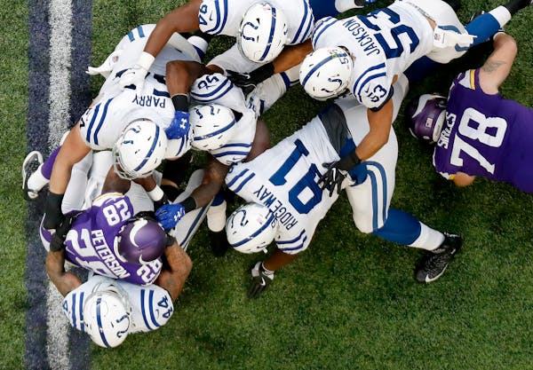 Minnesota Vikings running back Adrian Peterson was tackled by a group of Colts defenders in the first quarter. The carry was Peterson's first after re