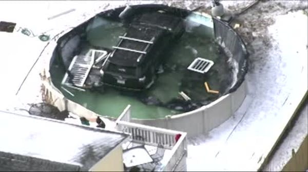 Raw: Car slides down icy driveway, lands in pool