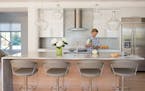 Andrea Swan can gaze at the river from her open modern kitchen featuring clear pendants etched with family names, durable laminate cabinets and irides