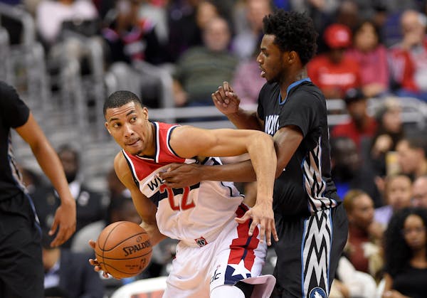 Washington Wizards forward Otto Porter Jr., left, dribbles against Minnesota Timberwolves forward Andrew Wiggins, right, during the first half of an N