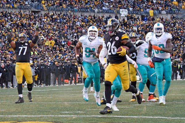 Pittsburgh Steelers running back Le'Veon Bell (26) scores on a short run during the second half of an AFC wild-card NFL football game against the Miam