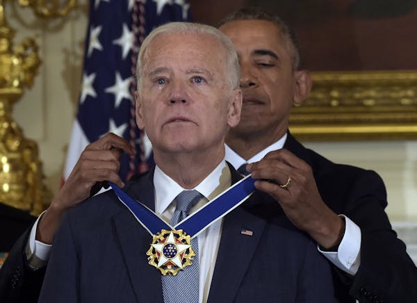 President Barack Obama presents Vice President Joe Biden with the Presidential Medal of Freedom during a ceremony in the State Dining Room of the Whit