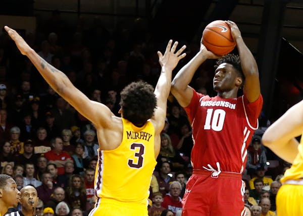 Wisconsin's Nigel Hayes, right, shoots as Minnesota's Jordan Murphy defends during the first half of an NCAA college basketball game Saturday, Jan. 21