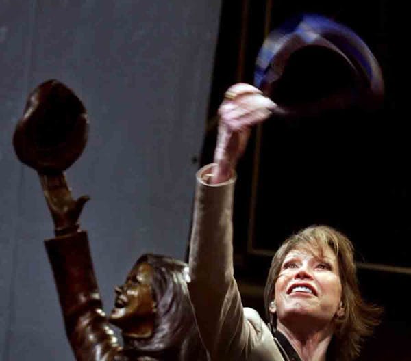 In the May 8, 2002, photo, actress Mary Tyler Moore, standing beside a statue of her in downtown Minneapolis, tossed another tam as the statue was unv