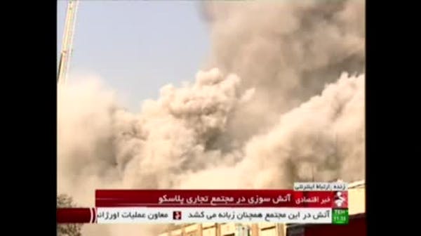 Raw: High-rise tower on fire In Iran collapses