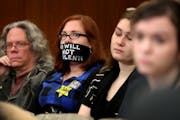 Protestor Amanda Wolfson, second from left, of St. Paul, sent a message without speaking while joining other protestors at a hearing that included dis