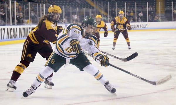 Clarkson’s Loren Gabel fired a shot while being defended by Gophers forward Kelly Pannek during the first period.