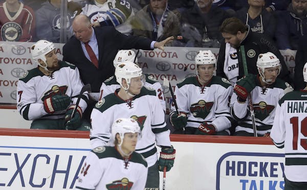 Minnesota Wild coach Bruce Boudreau talks to Chris Stewart on the bench during the third period in Winnipeg this week.