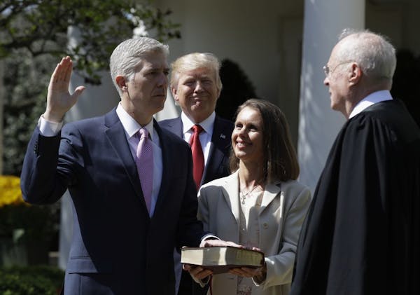 President Donald Trump watches as Supreme Court Justice Anthony Kennedy administers the judicial oath to Judge Neil Gorsuch during a re-enactment in t