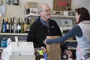 Steve Burwell, the owner of Fairview Wine and Spirits in Roseville, helps a customer.