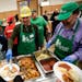 Ed Dols, center, a volunteer from Anoka, served up a piece of fried tilapia at Friday night's fish fry at St. Albert the Great Church.
