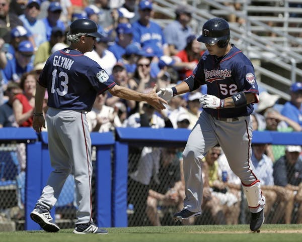Minnesota Twins' Byung Ho Park (52) shakes hands with third base coach Gene Glynn after Park hit a two-run home run off Toronto Blue Jays starting pit