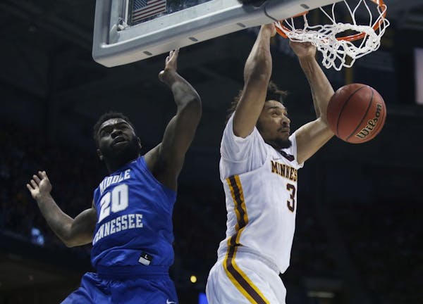 Minnesota's Jordan Murphy dunks past Middle Tennessee State's Giddy Potts during the second half of an NCAA college basketball tournament first round 
