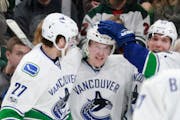 Canucks teammates congratulated Brock Boeser, center, after the Burnsville native scored against the Wild in his NHL debut.