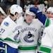 Canucks teammates congratulated Brock Boeser, center, after the Burnsville native scored against the Wild in his NHL debut.