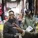 Khalid Mohamed, left, talks to Guled Hassan, right, and others about supporting Dine Out for Somalia while at Village Market.