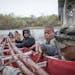 Members of the Micronesian community from Milan, Minnesota, prepare to bless and launch a 20-foot outrigger canoe into the Minnesota River underneath 