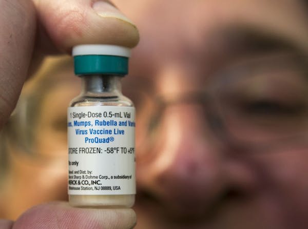 File photo: A pediatrician holds a dose of the measles-mumps-rubella (MMR) vaccine.