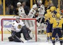 Chicago Blackhawks goalie Corey Crawford (50) looks up at the scoreboard as Nashville Predators players celebrate a goal by Filip Forsberg during the 