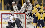 Chicago Blackhawks goalie Corey Crawford (50) looks up at the scoreboard as Nashville Predators players celebrate a goal by Filip Forsberg during the 