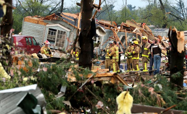 Firefighters work the site of the damage after a tornado ripped through Prairie Lake Estates trailer home park, just north of Chetek, Wis., Tuesday, M