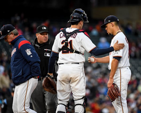 Twins catcher Jason Castro (21) patted starting pitcher Jose Berrios (17) on the shoulder after a visit to the mound by pitching coach Neil Allen on T
