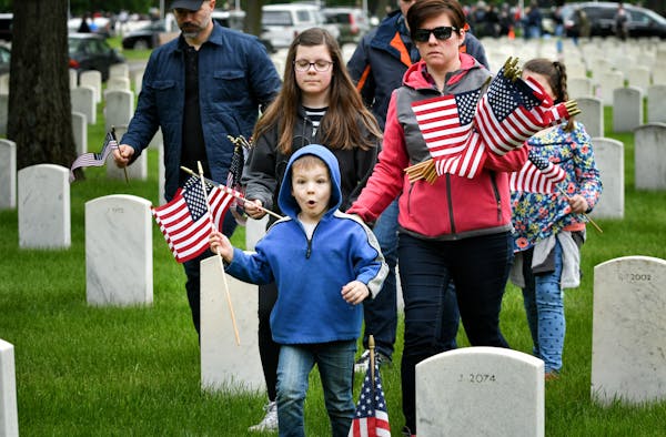 Max Payne, 5, found a grave marker where he wanted to place his flag. He came to Fort Snelling Monday with his parents Dave and Sonya and siblings Chl