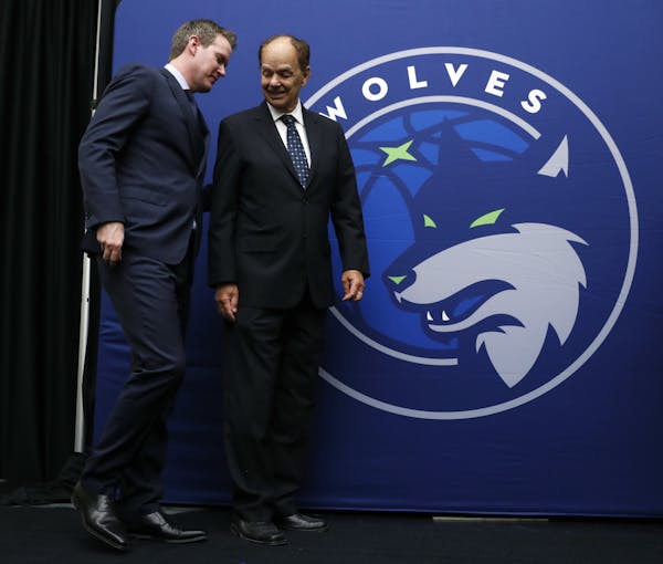 Minnesota Timberwolves CEO Ethan Casson, left, talks with Timberwolves majority owner Glen Taylor on Tuesday in front of the new Iowa Wolves logo. Ass