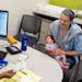 Megan Reid holds her 5-week-old son, Felix, while speaking to the nutritionist, Lucky Ahmed, as part of the WIC program at the South Hennepin County H