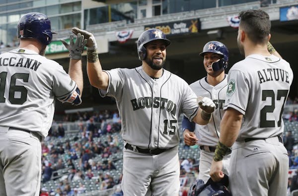 Houston Astros' Carlos Beltran, center, celebrates his three-run home run with teammates in the eighth inning of a baseball game against the Minnesota