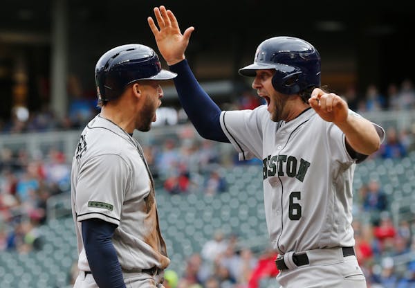 The Astros' George Springer, left, and Jake Marisnick celebrated as they score the tying and go-ahead runs against the Twins on a double by Josh Reddi